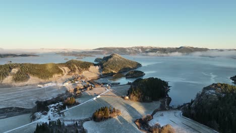 drone shot of a norwegian foggy snowy mountain landscape