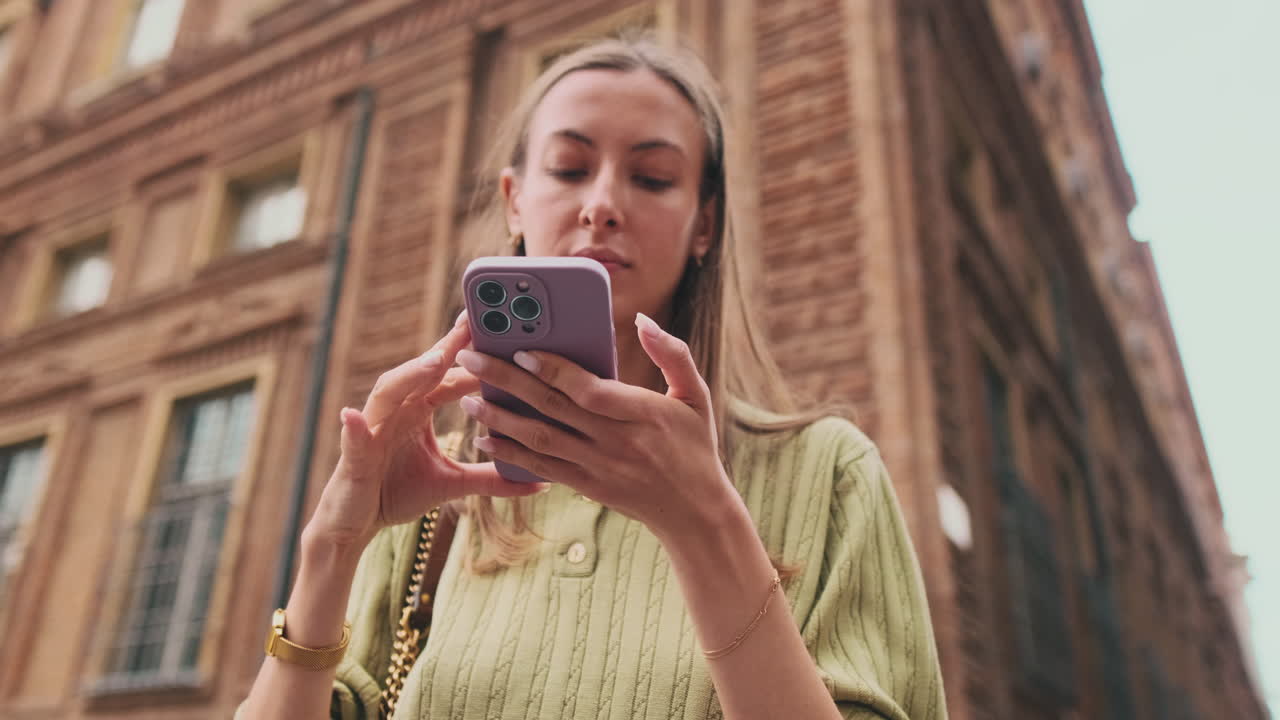Primo piano di giovane donna che usa lo smartphone in un contesto urbano