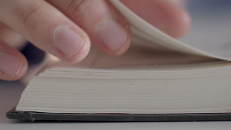 a man turns with his fingers pages in a book