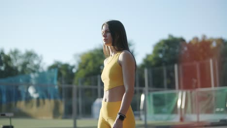 mujer corriendo en una pista al aire libre con ropa deportiva en un campo atlético