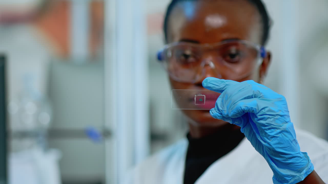 Close up of black chemistry doctor looking at virus test