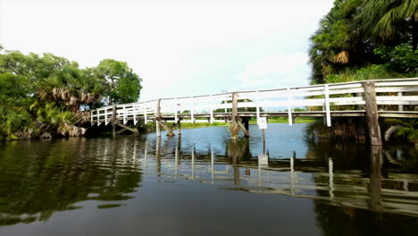 Coole-Aufnahme-Einer-Drohne,-Die-Unter-Einer-Brücke-über-Eine-Flussdronarchie-Hindurchfliegt