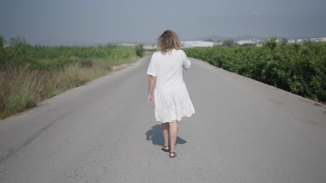 mujer caminando por un camino de campo