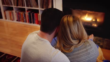 couple relaxing near fireplace in living room
