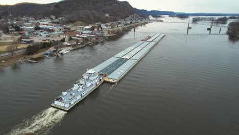 un remolcador empujando barcazas hacia el norte en el río mississippi se acerca al puente black hawk en lansing, iowa-1