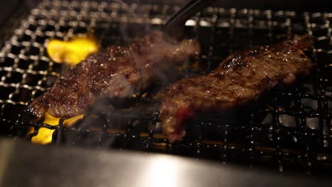 steak being grilled, flipped, and sizzled on a grill
