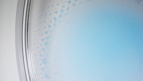 abstract macro shot of blue alcoholic ink spreading in liquid in a dreamy soft motion
