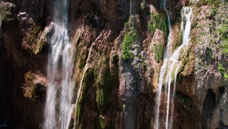 Drone-slow-motion-ascent-revealing-Croatian-village-surrounded-by-waterfalls