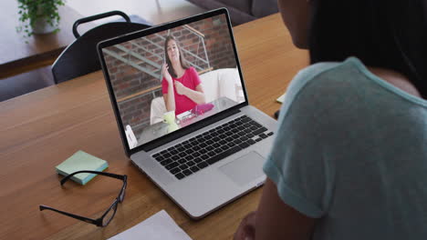 african american woman having a video call with female office colleague on laptop at home