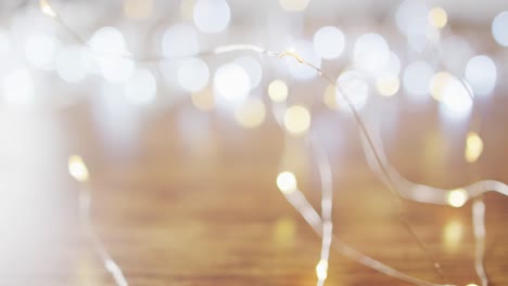 video of lit fairy lights christmas decorations and bokeh lights on wooden background