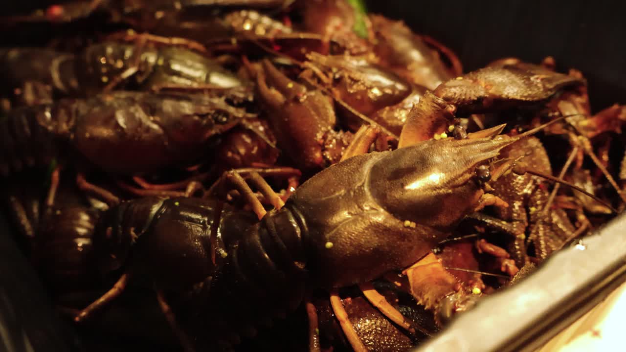 Close up view of brown and red colored crayfish crabs or lobsters moving and crawling around in a box on a kitchen table just before they are ready to be boiled and cooked. Good lighting on the crabs