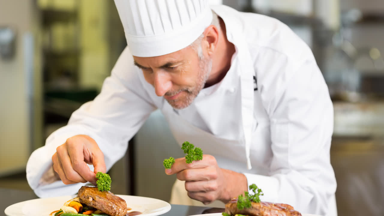 un chef caucásico sonriente con un delantal preparando comida en una cocina profesional