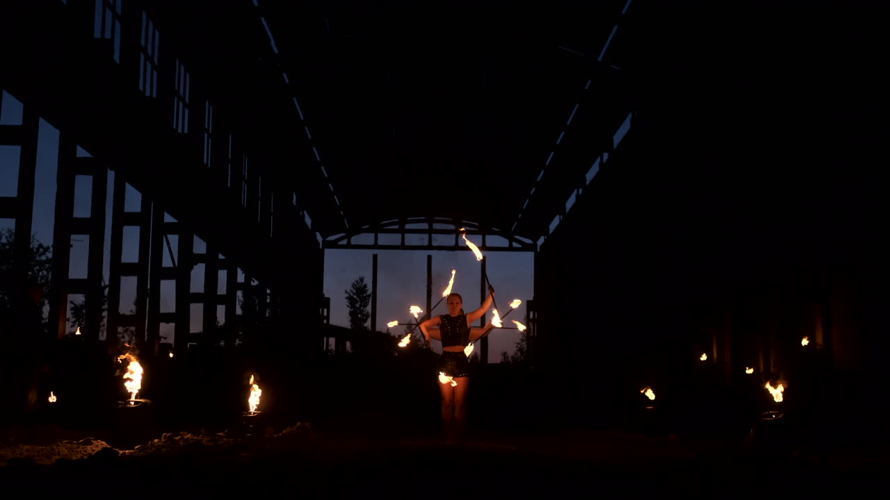 A group of professional artists with fire show the show juggling and dancing with fire in slow motion