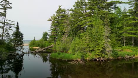 Aerial-view-of-small-forested-lake-inlet,-Lake-Superior,-Michigan