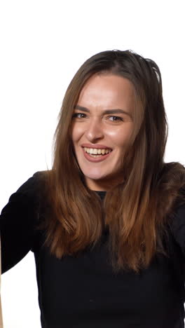 positive human emotions. pretty young woman with shopping bags after successful shopping, smiling and looking at the camera on a white background vertical video