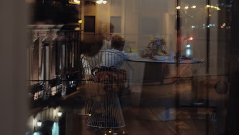 madre con su hijo en la mesa reflejándose en la ventana por la noche