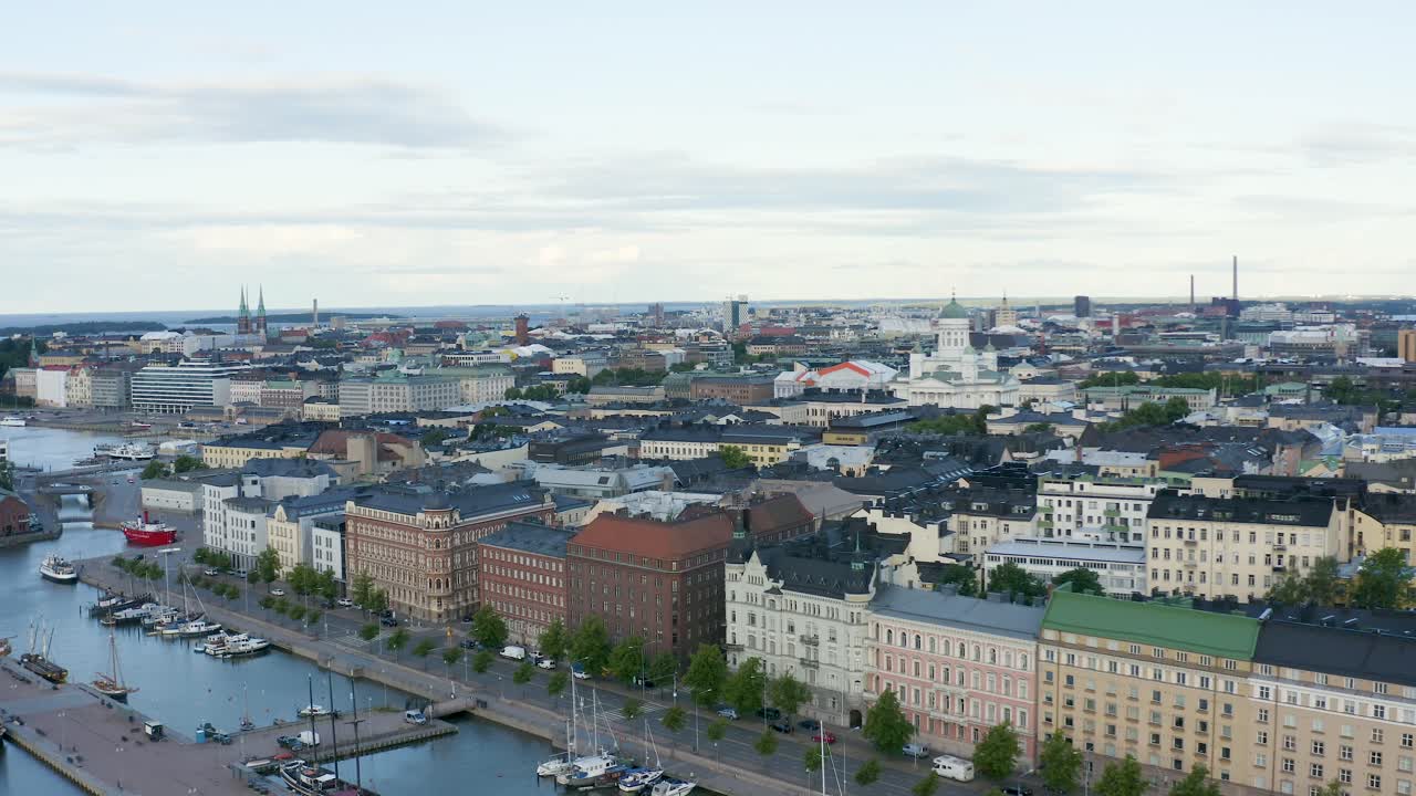 Lenta panoramica aerea di edifici e cattedrale lungo il lungomare di Helsinki al tramonto, Finlandia.
