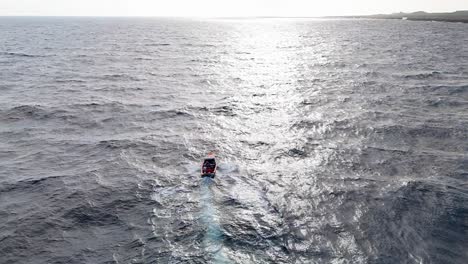 fishermen drive boat out to sunset crashing over open ocean water wave peaks