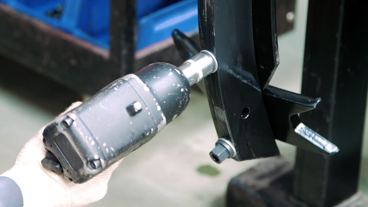 공장에서 기압 렌치로 일하는 전문 기계사