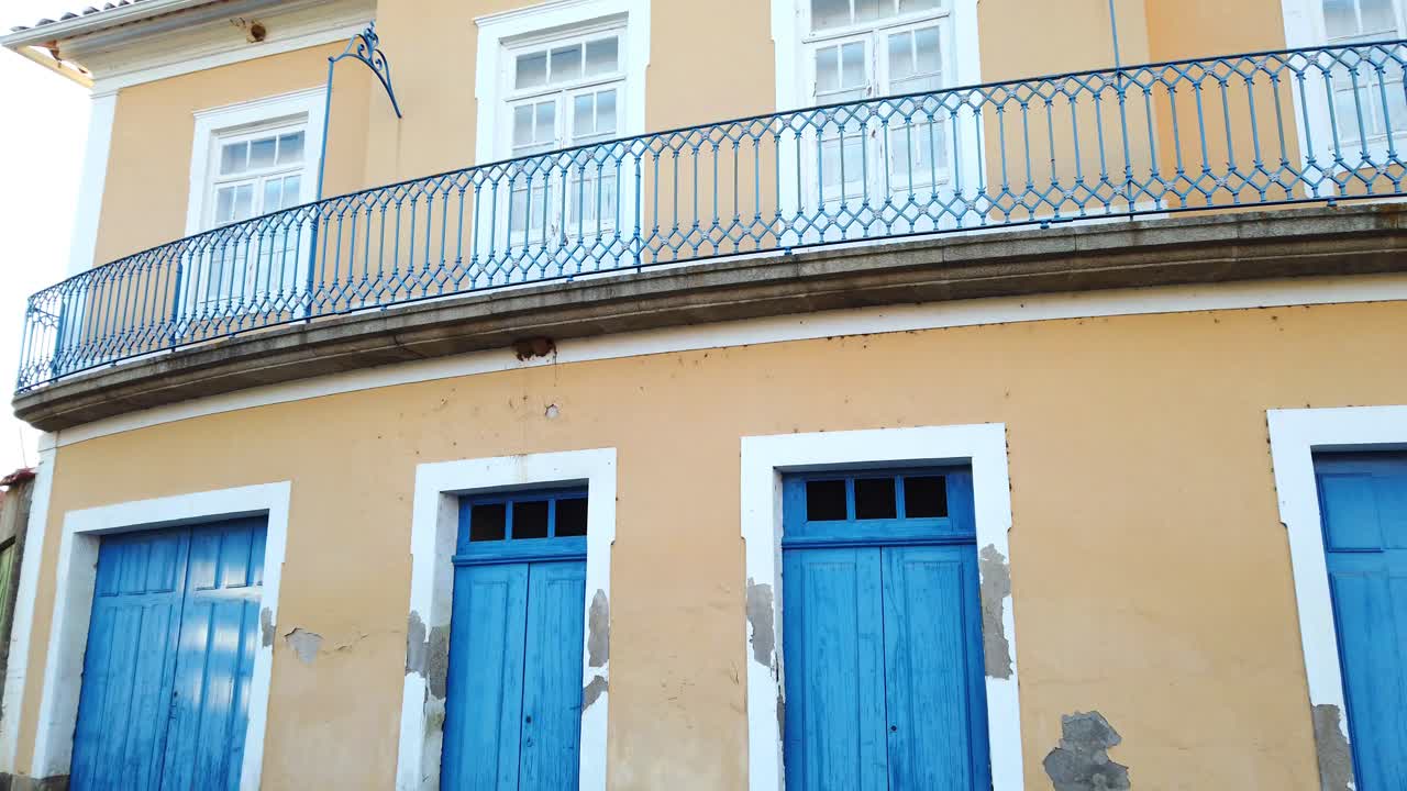 casa de la ciudad portuguesa con colores tradicionales, paredes amarillas y puertas azules