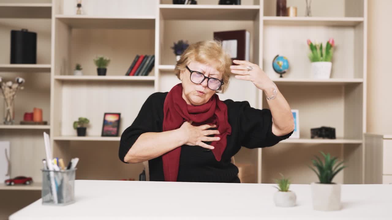 테이블 에 앉아 있는  ⁇ 은 여자 는 가 ⁇  을 손 으로 잡고 심장 마비 를 겪으면서 마사지 를 시작 한다