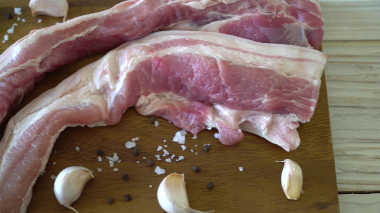 재료가 있는 나무 판자에 있는 신선한 생줄무늬 돼지고기