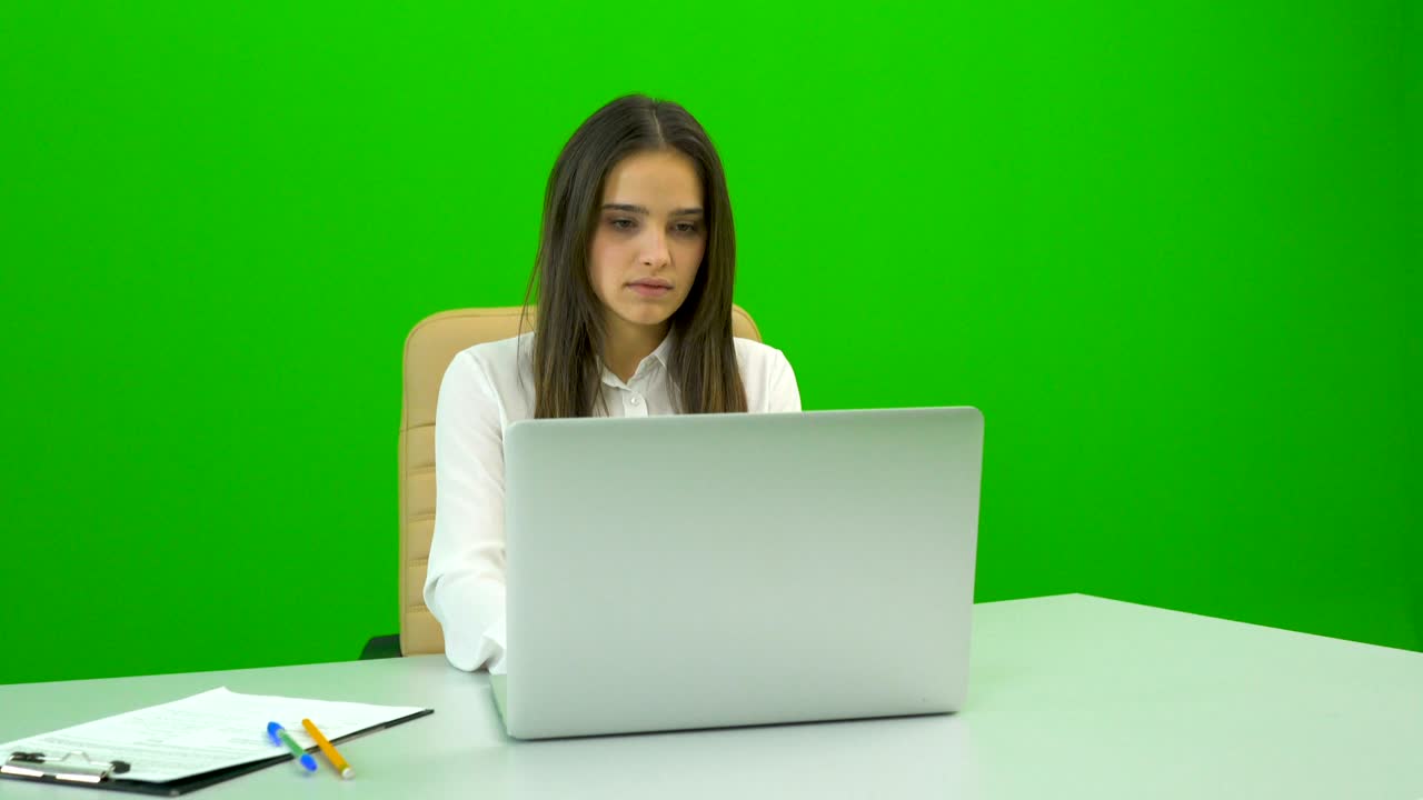 The businesswoman working at the desktop on the green background