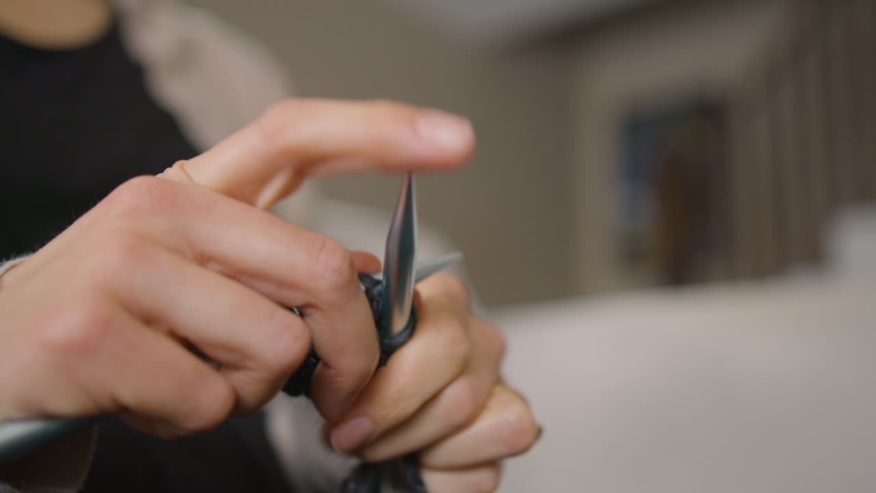 Learning to knit. Close up, slow motion, low angle.