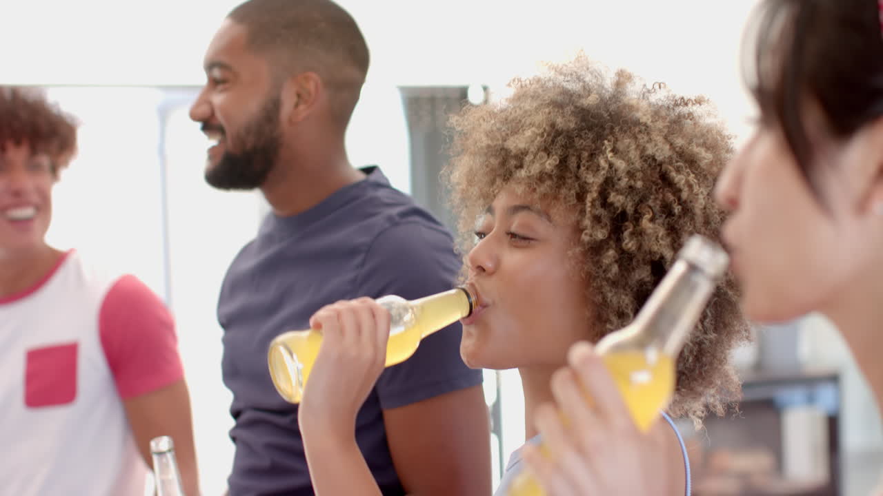 Diverse friends hanging out, drinking bottled beverages, enjoying social time together