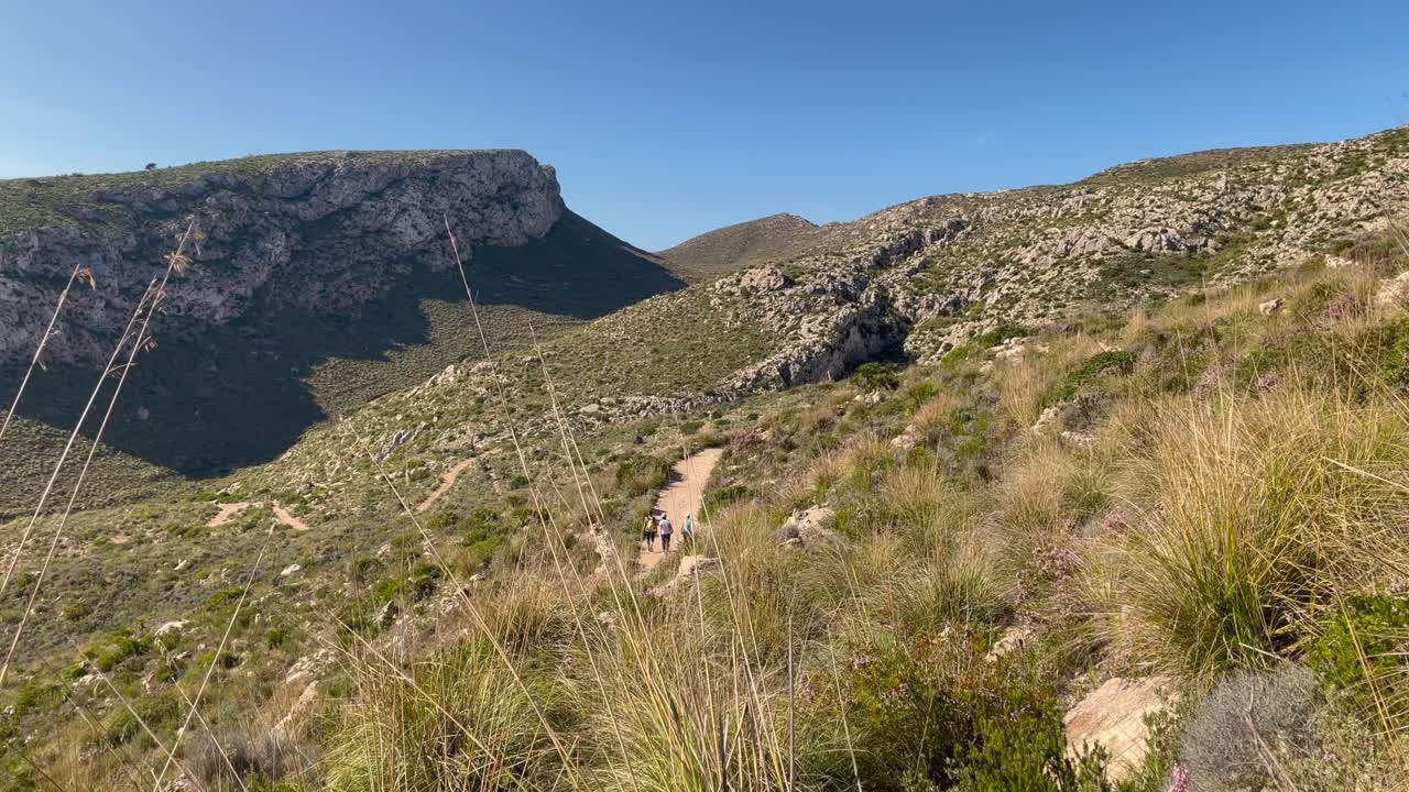 revelar personas caminando en la distancia en la naturaleza, fondal de ses basses mallorca, españa