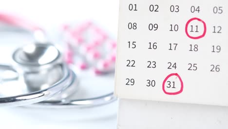 medical appointment calendar with stethoscope and pills