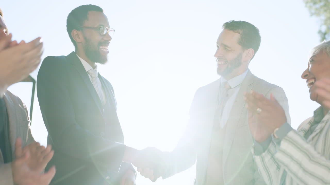 Handshake, hug and applause with a business team