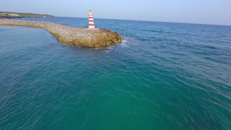 Fpv-drone-flying-over-lighthouse-and-toward-Hotel-Hilton-Garden-Inn-of-La-Romana-in-Dominican-Republic