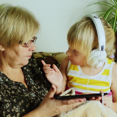 Grandma-And-Granddaughter-Using-Tablet-Together-02