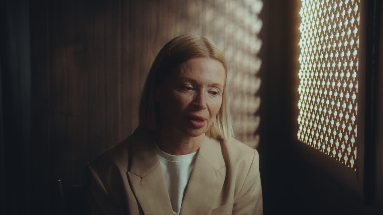 Senior Woman Performing Sacrament of Penance in Confessional Booth