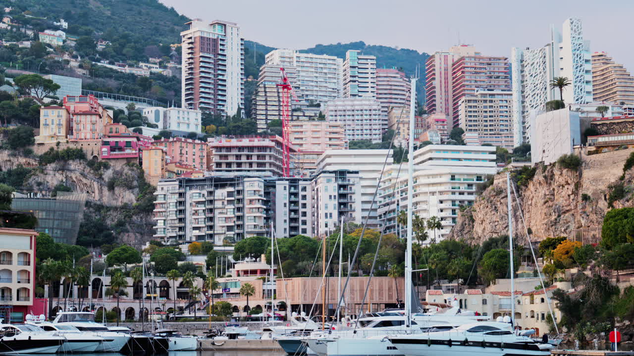 View of boats docked in the Monaco Marina with the skyline of the city on the background