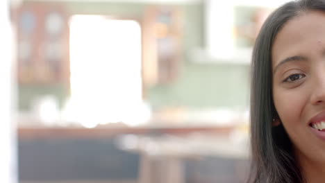 Close-up-of-a-young-biracial-woman-at-home,-with-copy-space