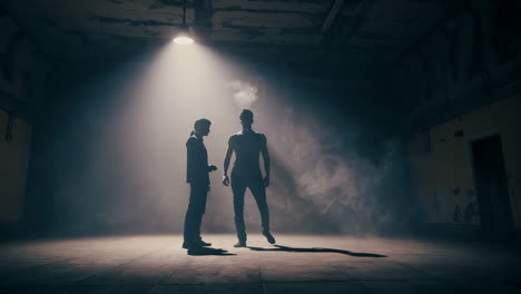 two men in a dark industrial room