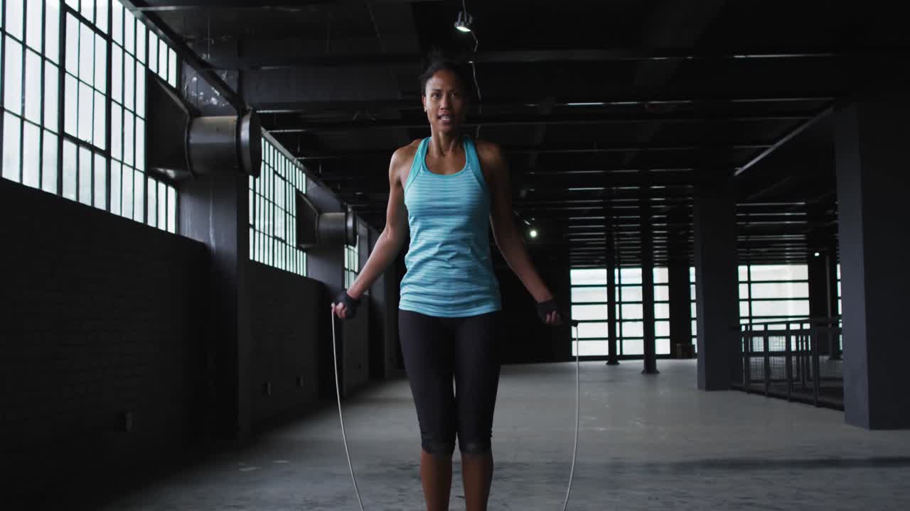 African american woman skipping the rope in an empty urban building