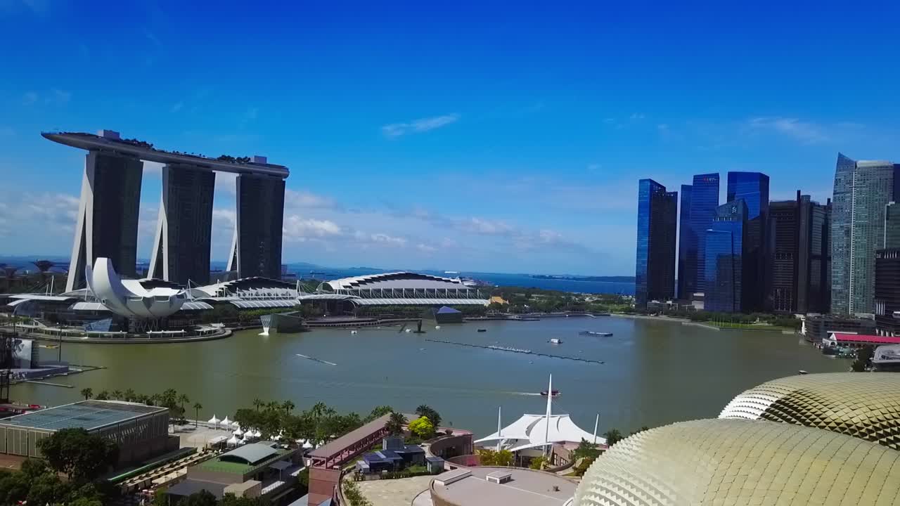 Aerial drone shot panning right from Marina Bay Sands, revealing the stunning skyline of Singapore