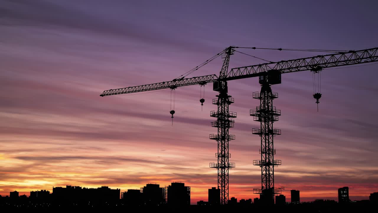 Construction Crane at Sunset over City Skyline