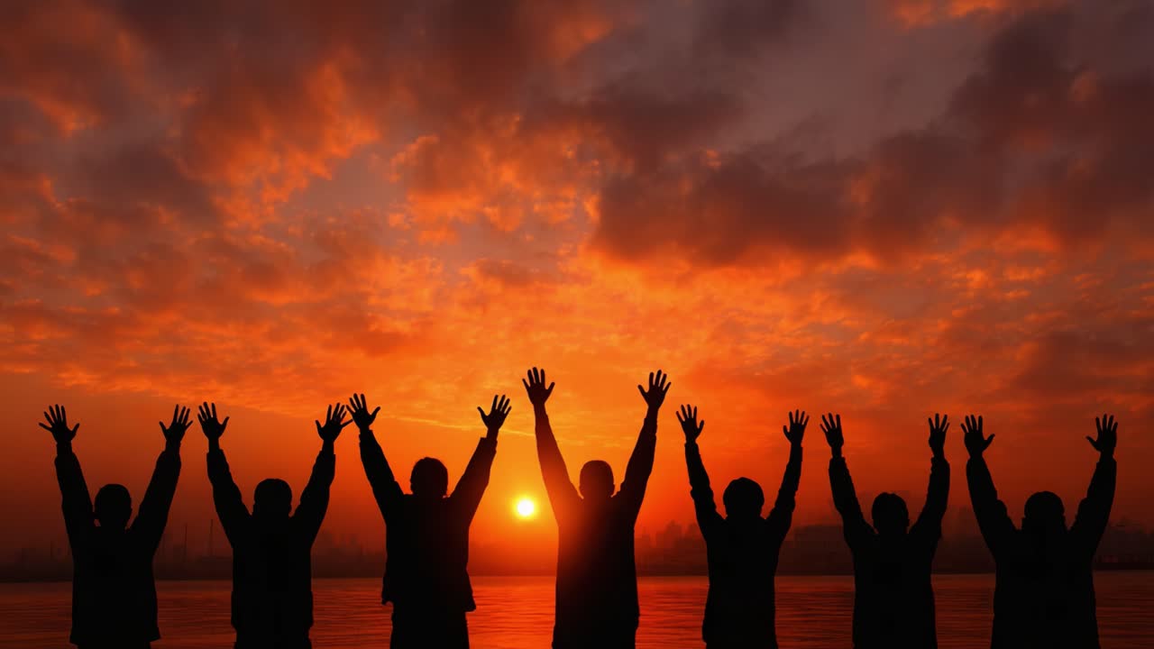 Group Silhouette Celebrating a Breathtaking Sunset with Raised Hands Against a Vibrant Sky Transitioning from Day to Night