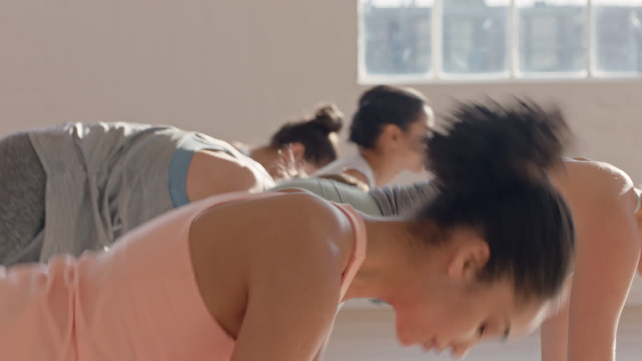 요가 수업 코브라 포즈를 연습하는 아름다운 혼혈 여성이 일출 때 피트니스 스튜디오에서 건강한 라이프스타일을 즐기고 있습니다.