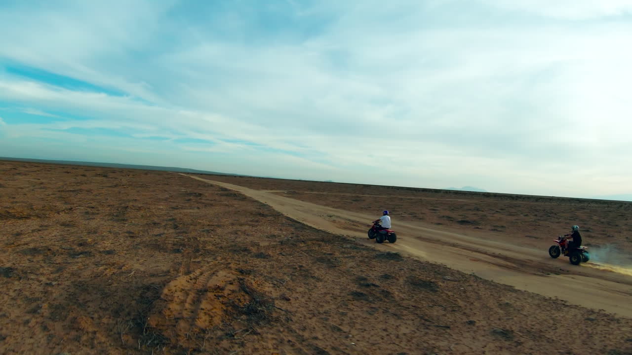Guidando tricicli motorizzati fuoristrada lungo un sentiero sterrato nel deserto del Mojave - al rallentatore
