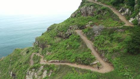 a man with a backpack is walking alone up the long trail to the top of the mountain in madeira