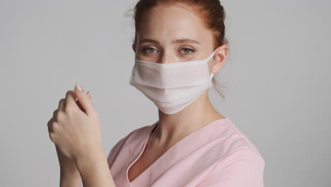 Redheaded-doctor-in-front-of-camera-on-gray-background.