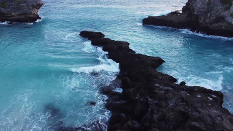 aerial drone shot over the rocky coastal blue lagoon in nusa ceningan, bali