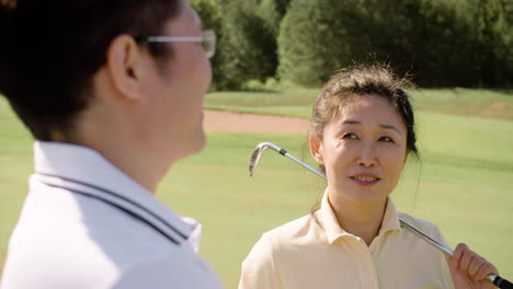 Asian-man-and-woman-talking-about-golf-on-the-field