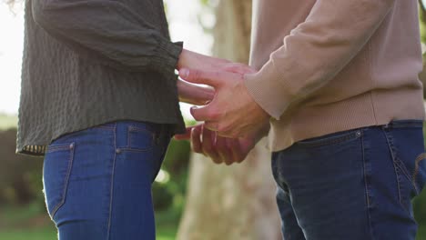 video of happy caucasian husband and wife holding hands and touching heads in garden