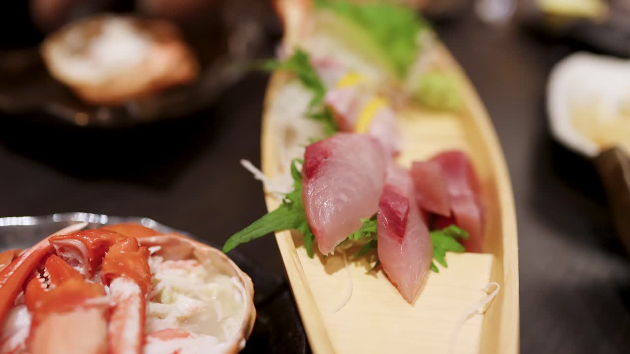 Primo piano di pesce crudo e zampe di granchio serviti in un ristorante a Tokyo, Giappone